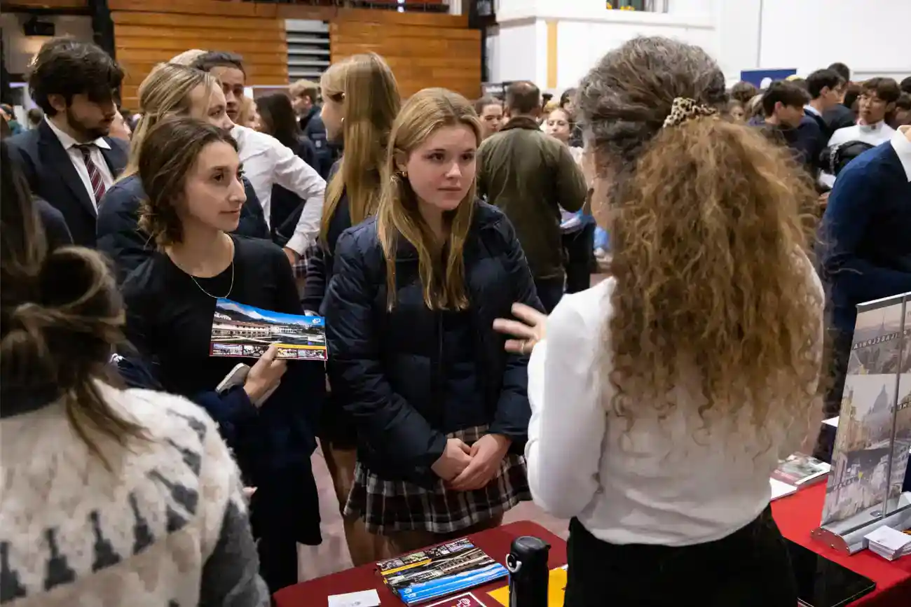 This Year at TASIS: 2023 43 Interaction between students and an education counselor at a World Schools event showcasing international school opportunities.