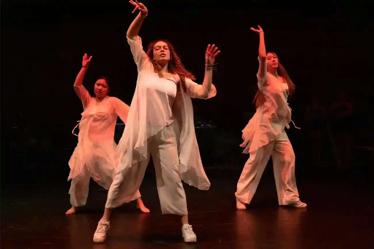 This Year at TASIS: 2023 47 Energetic girls performing contemporary dance on stage at a world school cultural event.