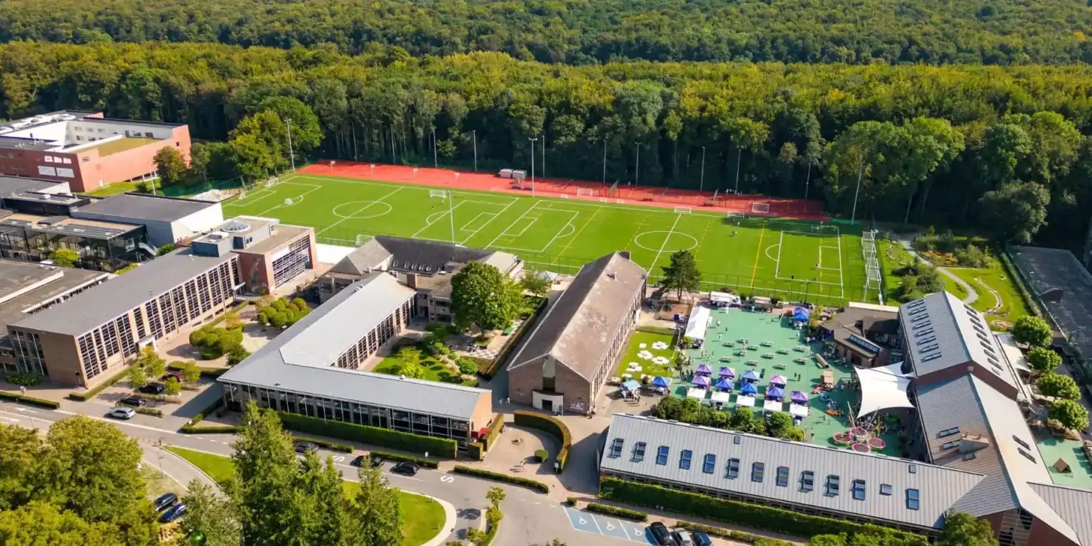 Modern school campus with sports fields and outdoor activity areas.