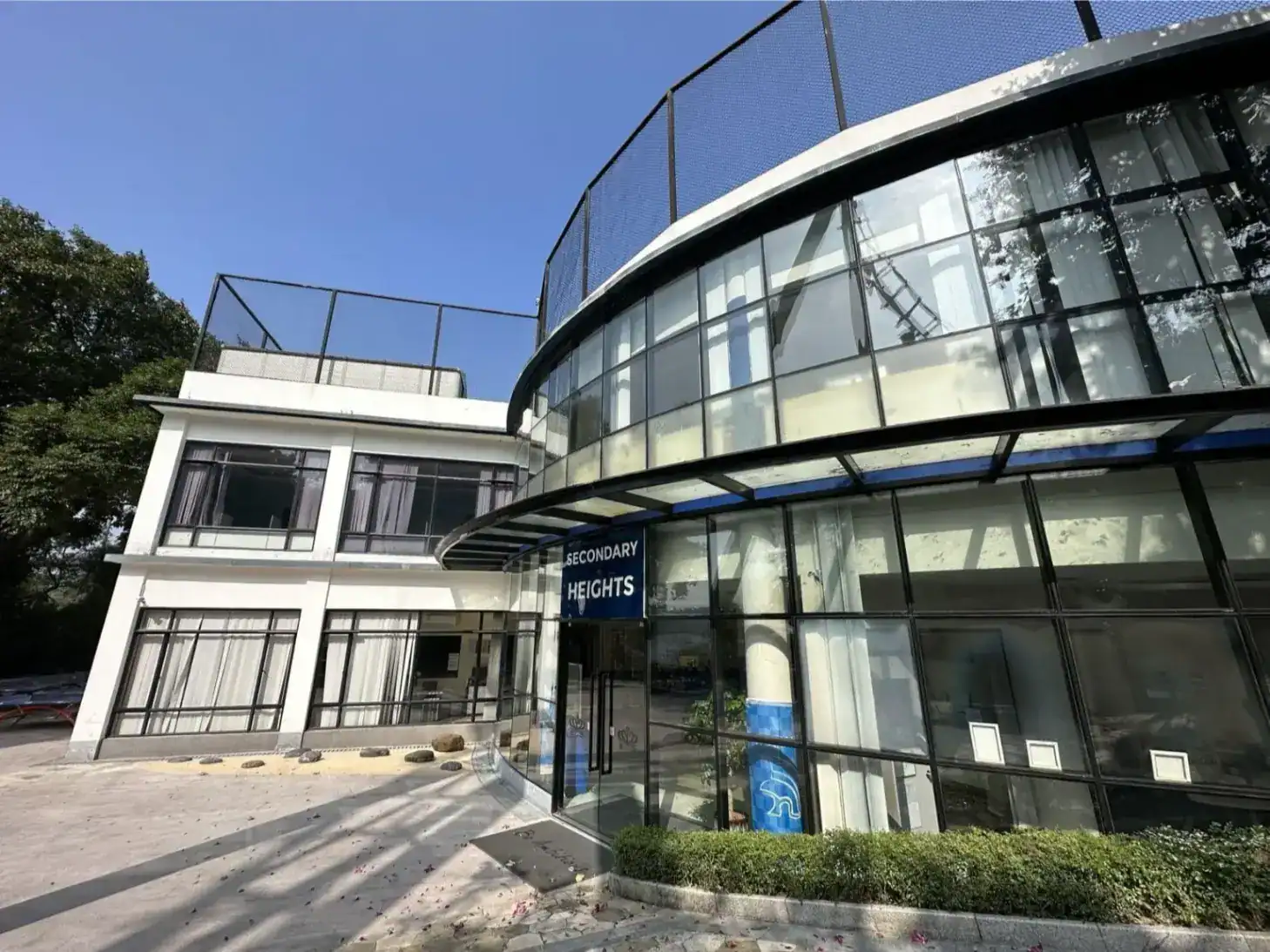 Modern secondary school building with glass facade at World Schools campus.