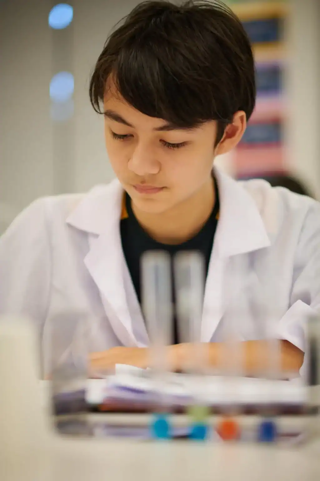 Focused student studying with microscope in a modern classroom, emphasizing quality international education at World Schools.