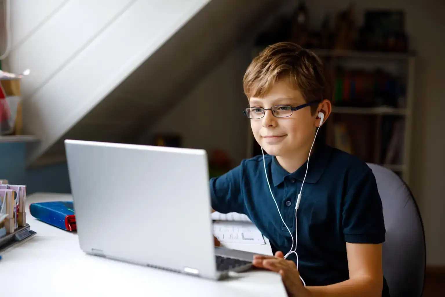 Young boy studying online with a laptop, engaging in remote learning at home.