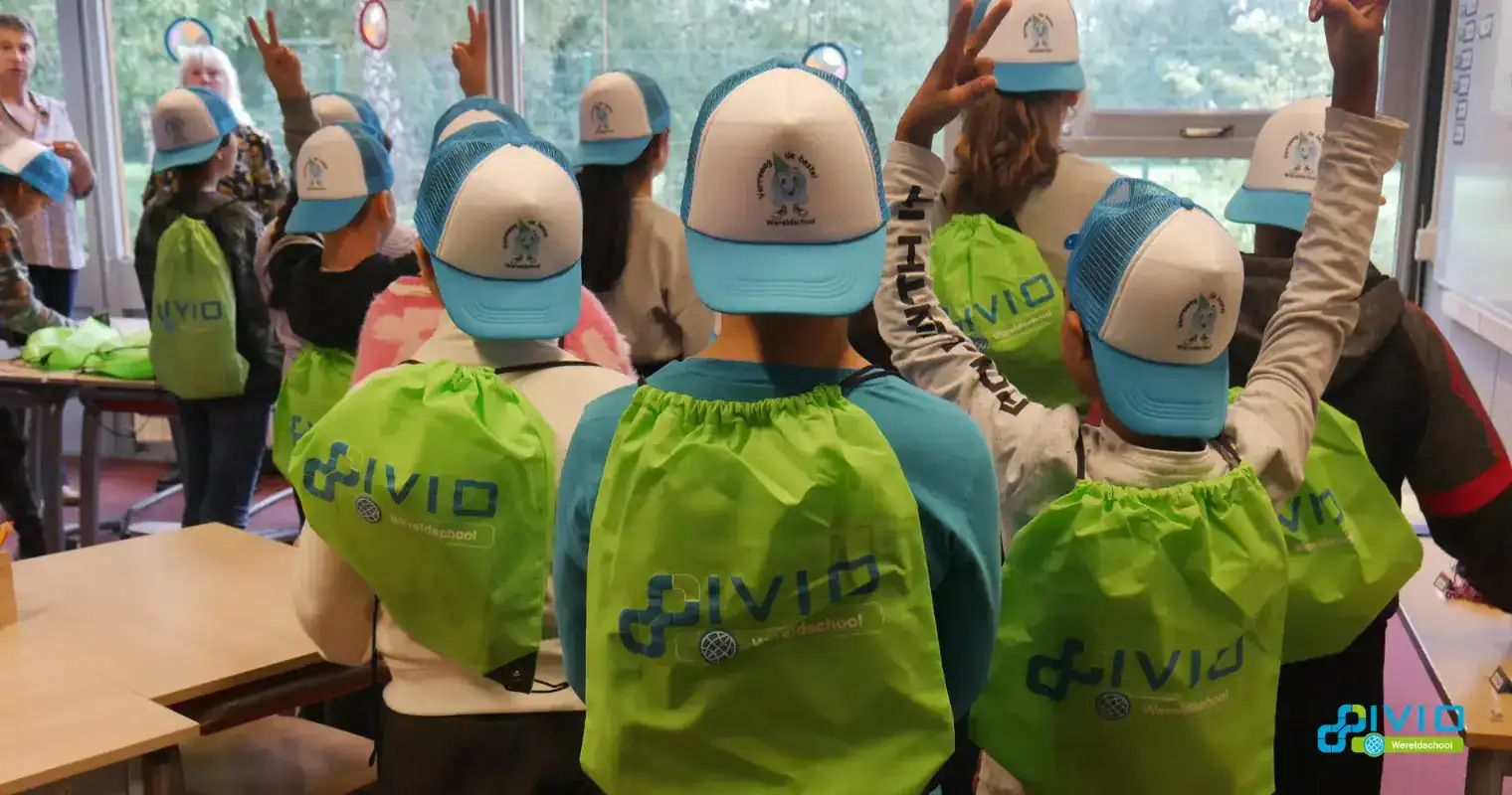 Vivo Wereldschool kids in classroom with green backpacks and caps, engaging in educational activities.