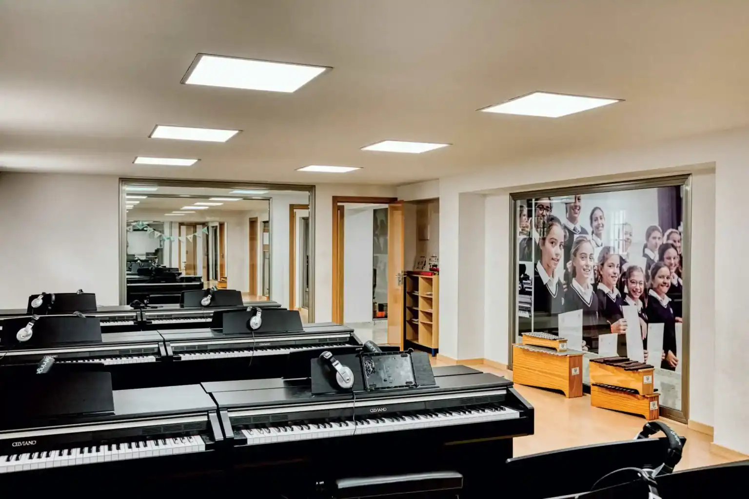 Modern music classroom with pianos and headphones at a top international school.