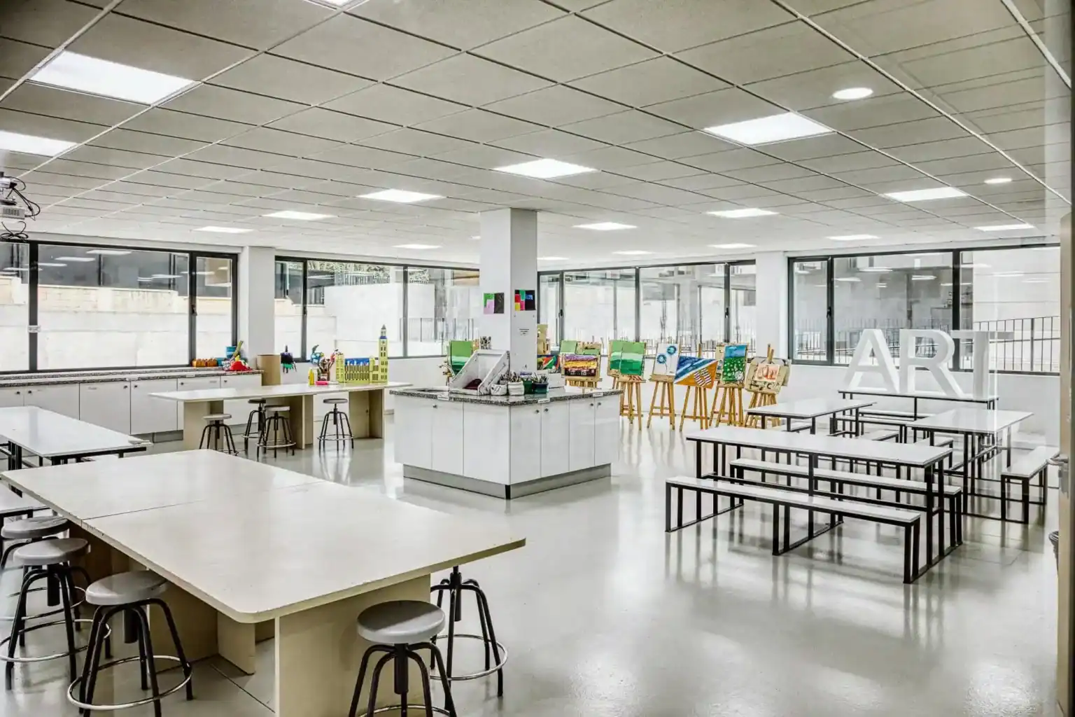Bright modern art classroom at an international school with student artwork displays.