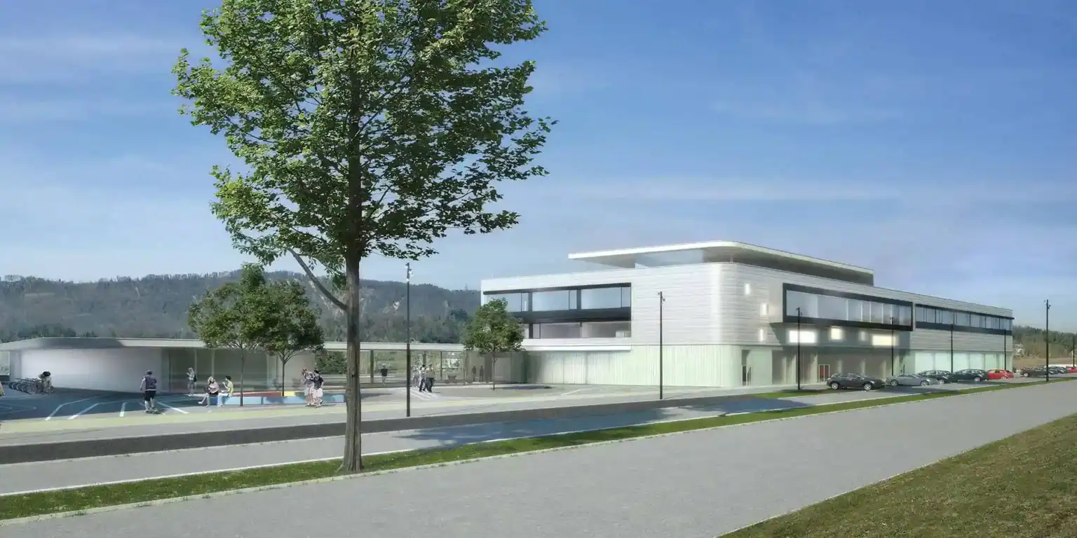 Modern educational building with spacious outdoor areas, surrounded by trees and designed for student learning and activities.