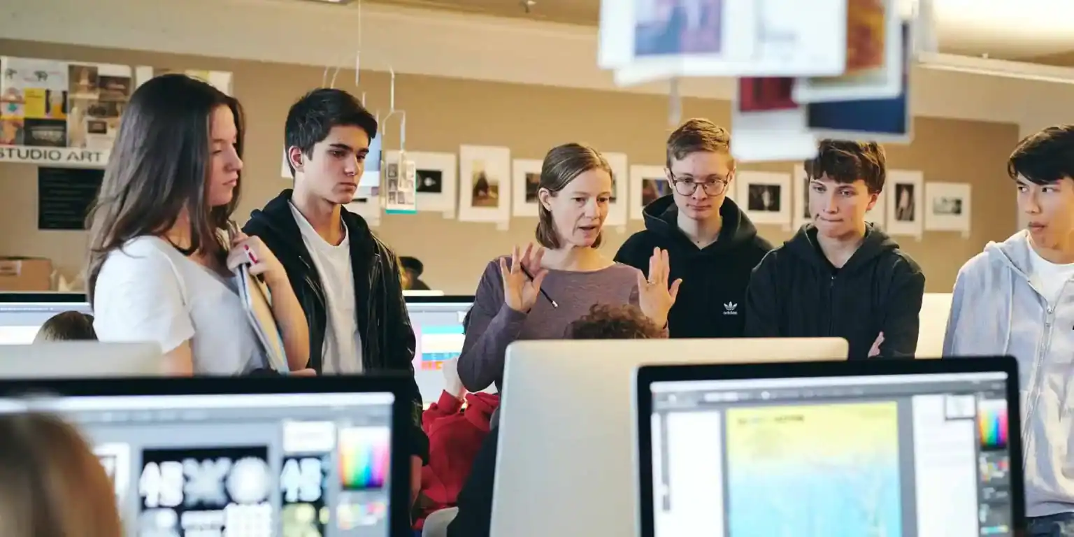 Interactive classroom with diverse students and teacher discussing digital art and multimedia technology.