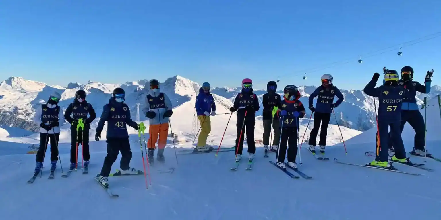 Skier group at a world-class ski resort in snowy mountains, promoting sports and outdoor activities for international students.