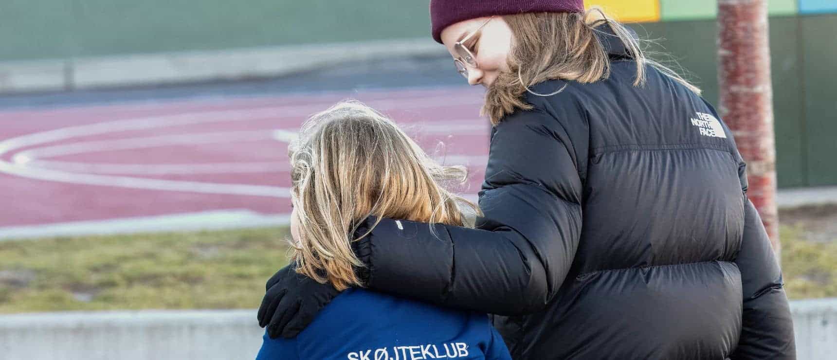 World Kindness Day celebrated at Copenhagen International School 3 Compassionate adult comforting a child outdoors at a school playground.