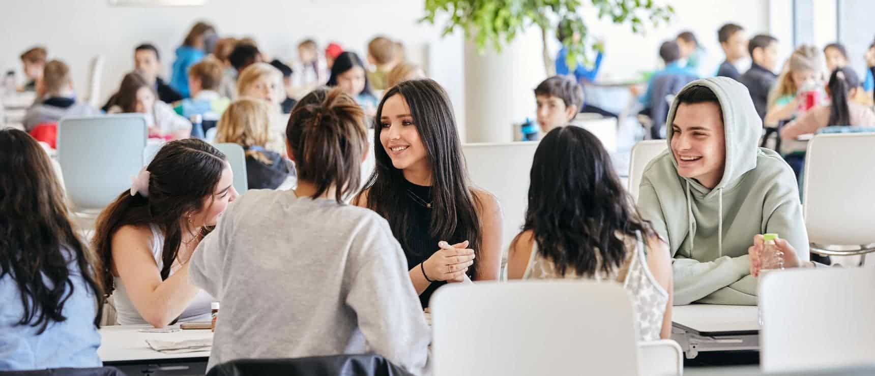 Smart diverse students engaging in discussion at modern school, international education setting, World Schools image.