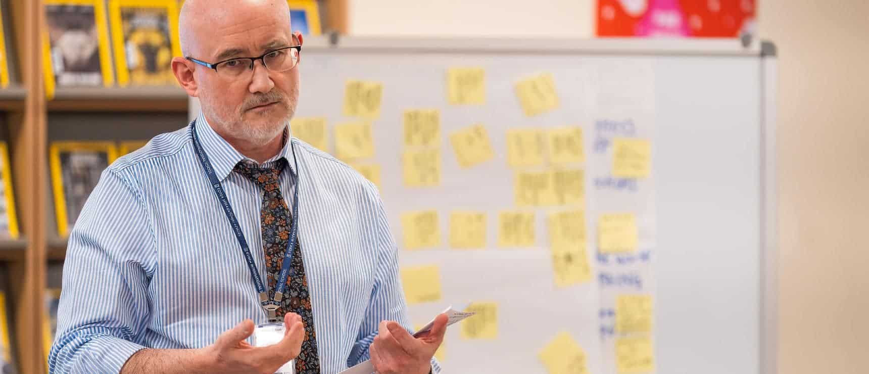 Professional educator analyzing classroom planning at a world schools conference.