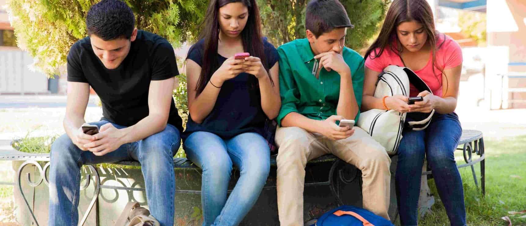 Engaged students using smartphones at a balanced and diverse global school environment.
