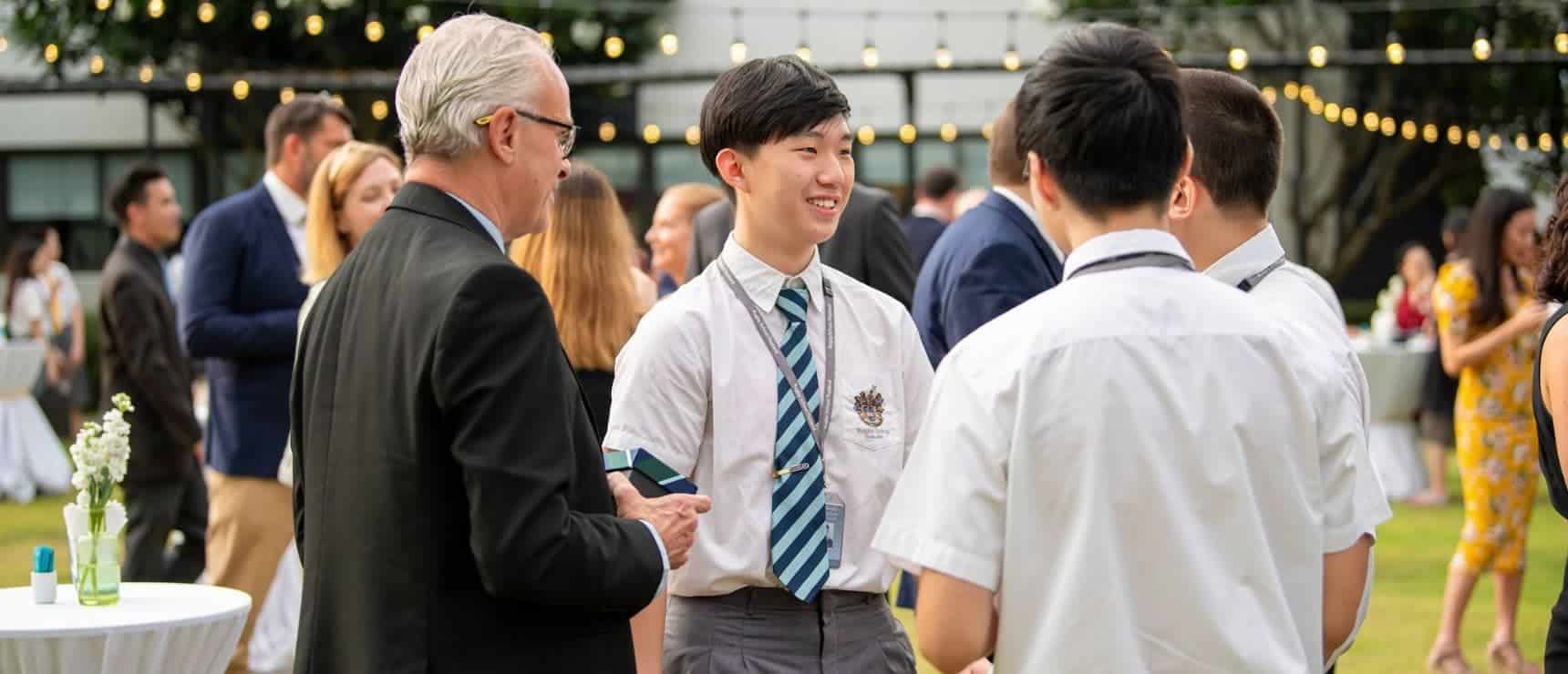 Enrolled students networking at a vibrant outdoor school event, showcasing global student community and education excellence.