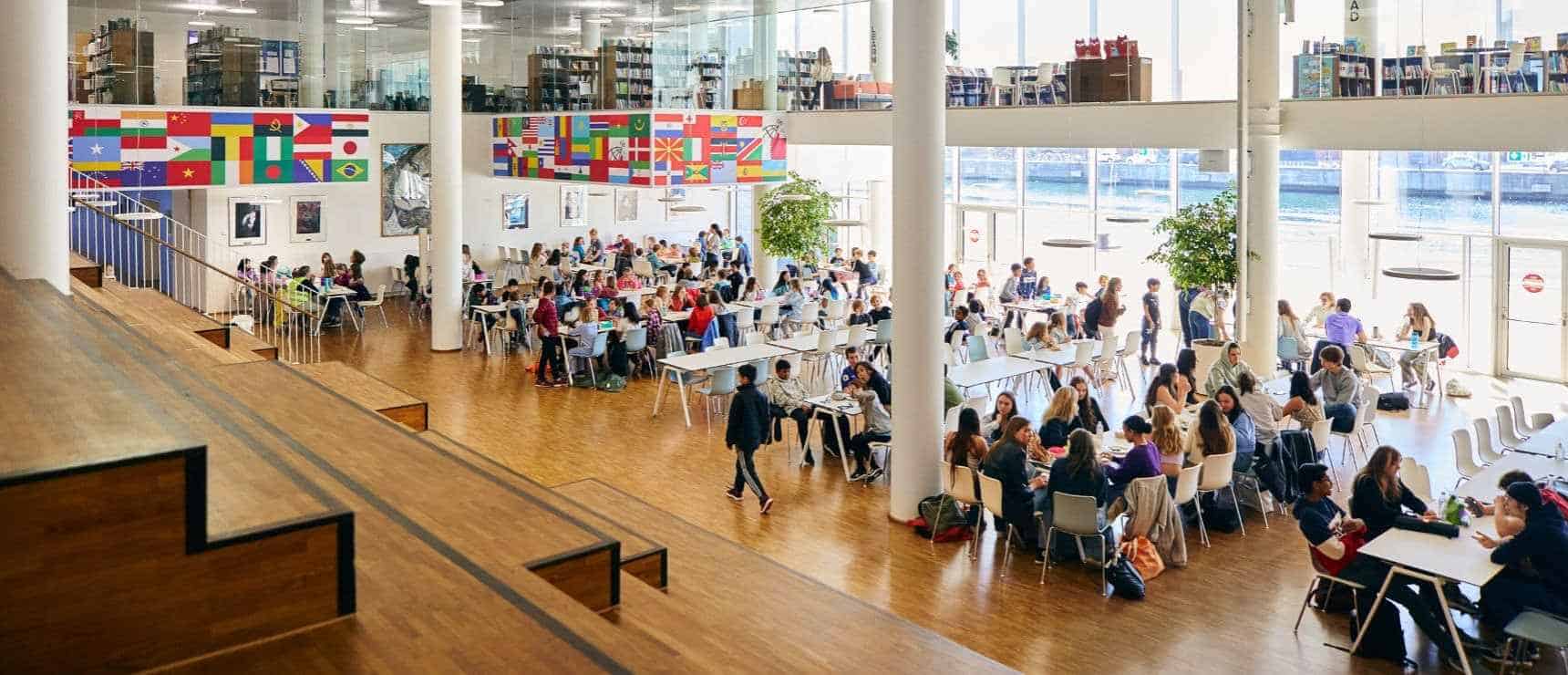 Racial and Social Justice Union - Real World Practice of Global Citizenship Education 5 Bright, global student cafeteria at World Schools with international flags, fostering diversity and cultural exchange.