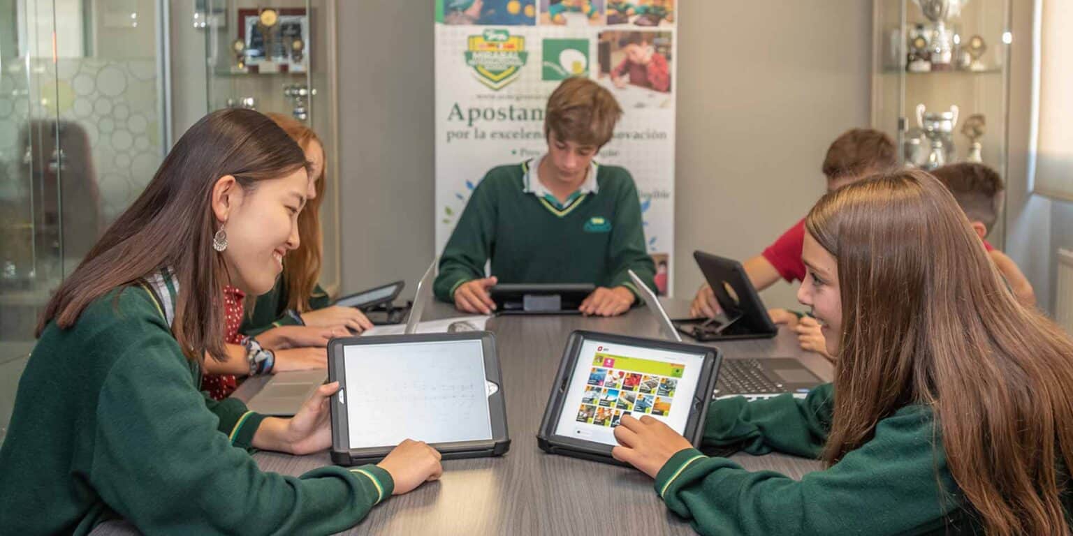 Students using tablets in a modern classroom at World Schools for enhanced digital learning.