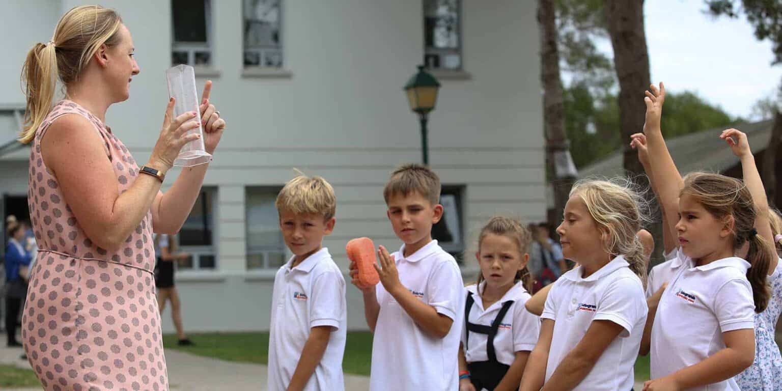Students engaging with a teacher outdoors to learn about nutrition and healthy eating habits.