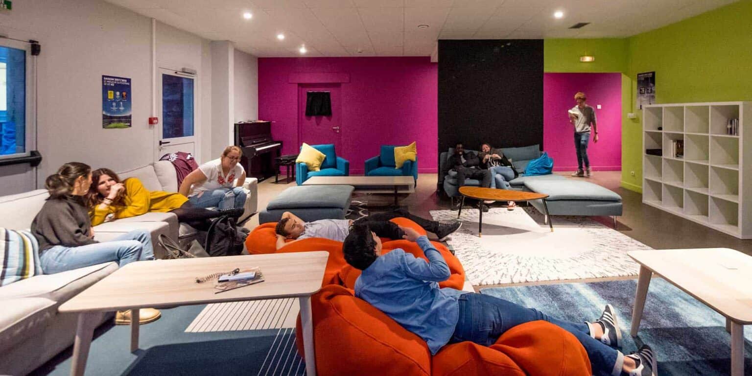 Cozy student lounge with vibrant walls, comfortable seating, and social area at a world school campus.