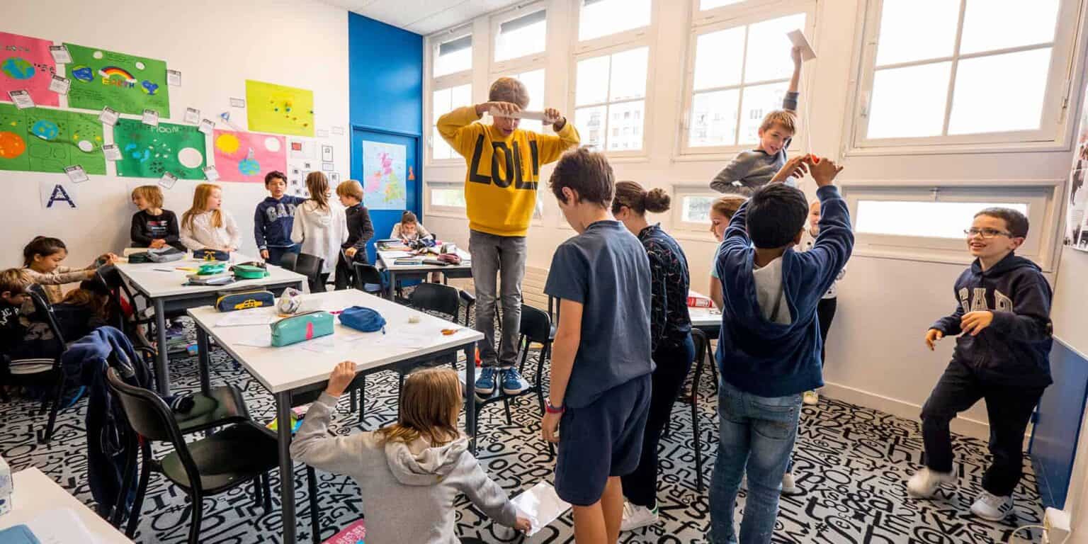 Busy classroom of diverse elementary students engaging in hands-on learning activities.