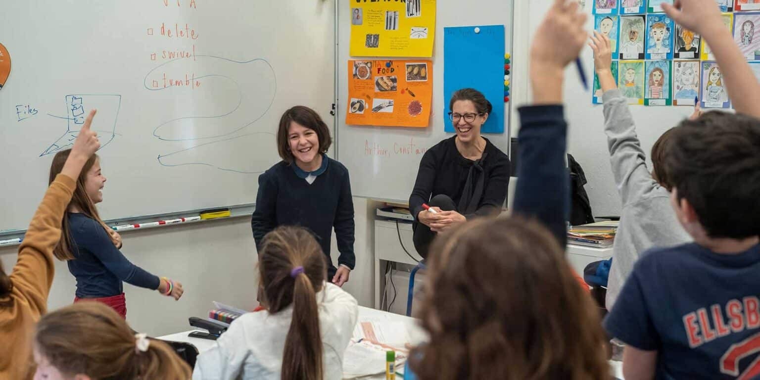 Engaging classroom scene at a World School with diverse students and a passionate teacher in a vibrant learning environment.