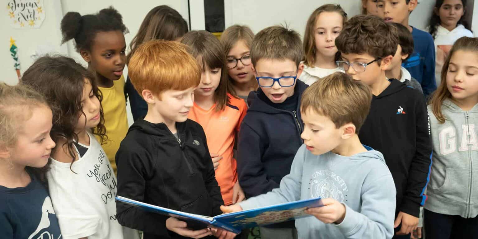 Children engaged in a classroom reading activity at a World Schools educational setting.