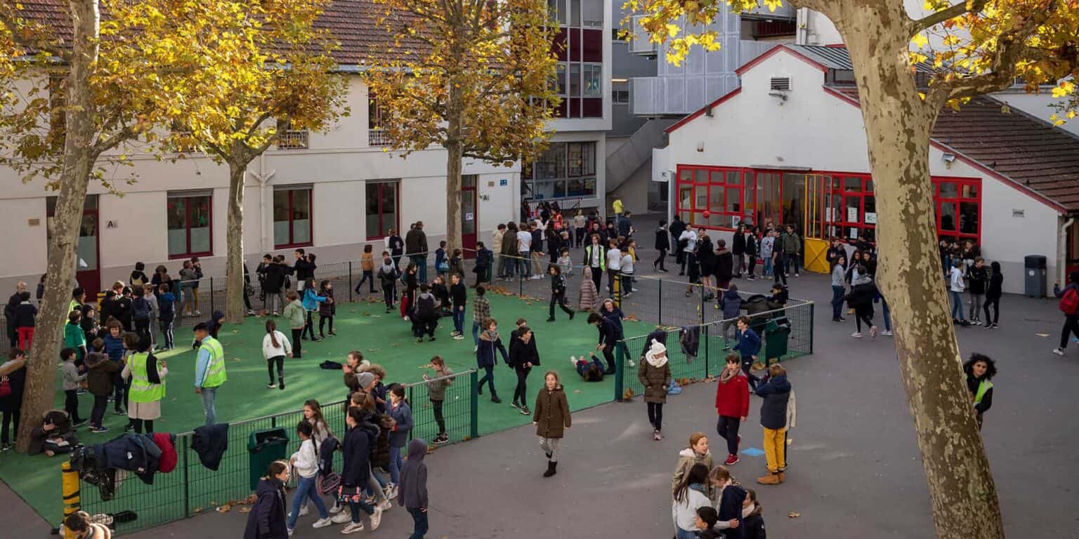 Modern international school campus with students during recess and outdoor activities.