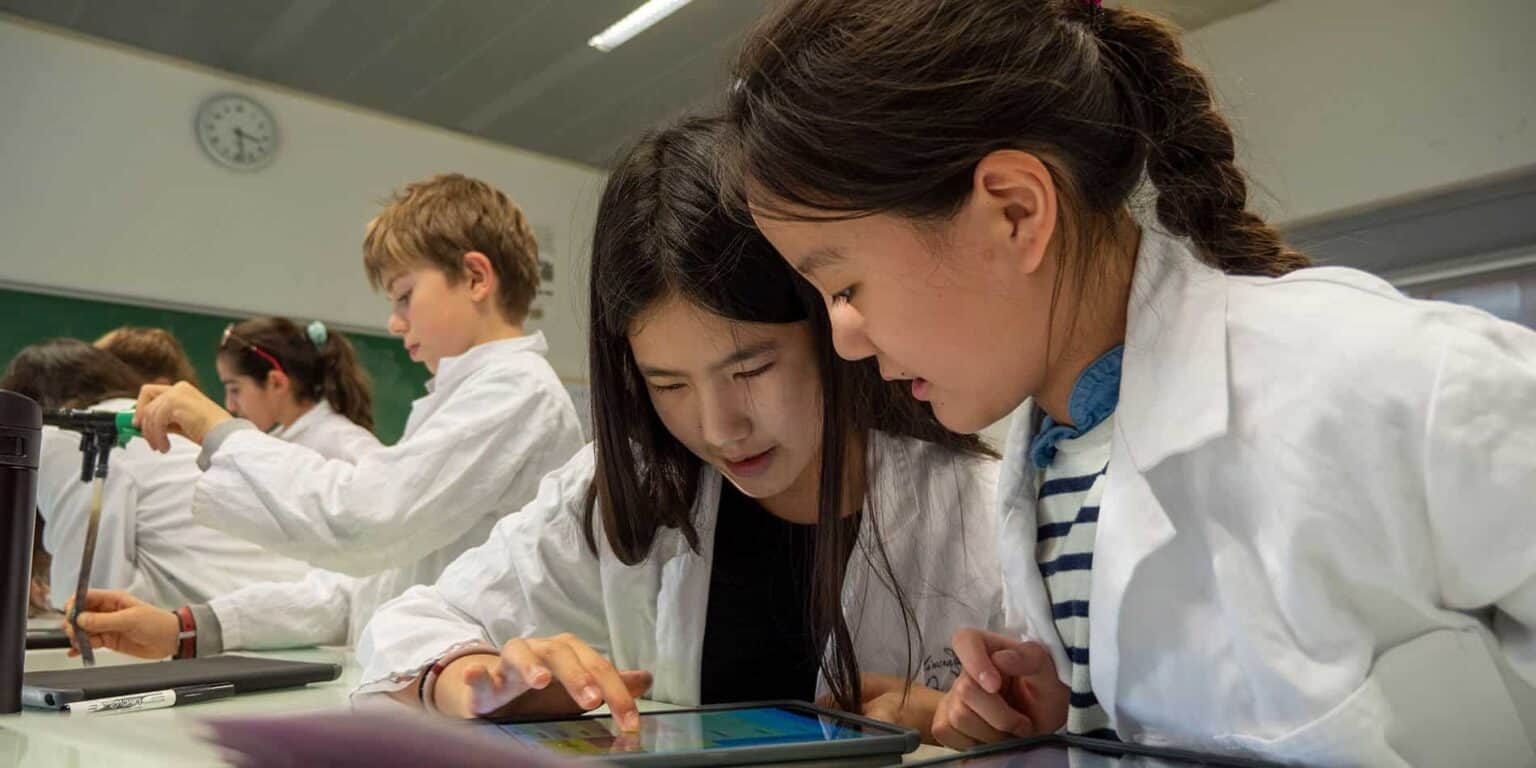 Innovative international students collaborating in a science classroom at a prestigious world school.