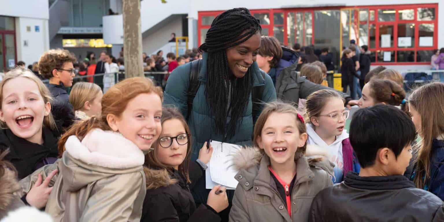 Smiling children and teacher outdoors at World Schools event, fostering global education and cultural exchange.