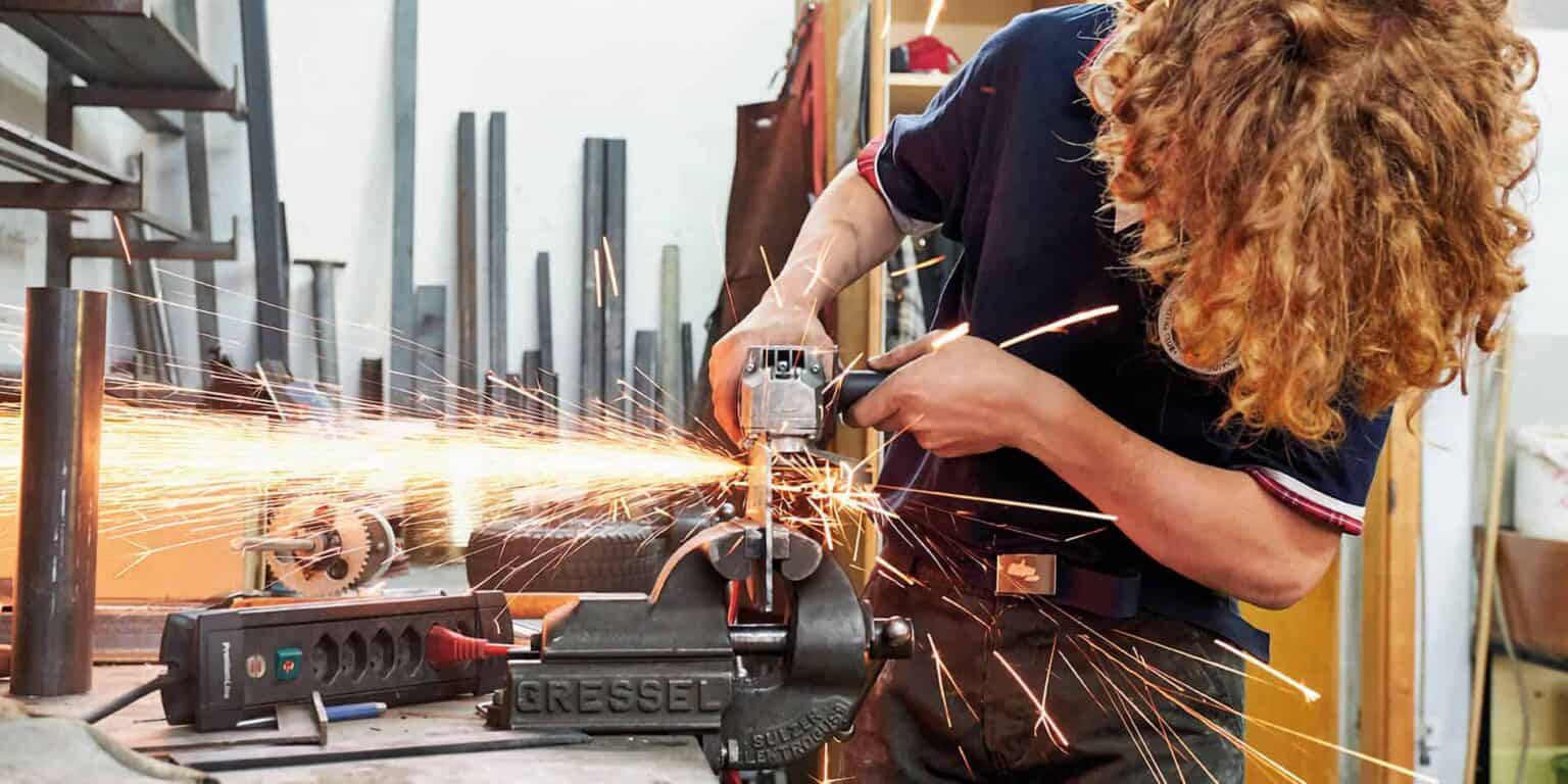 تتطاير شرارات قوية أثناء انخراط طالب في أعمال المعادن في مدرسة مهنية.