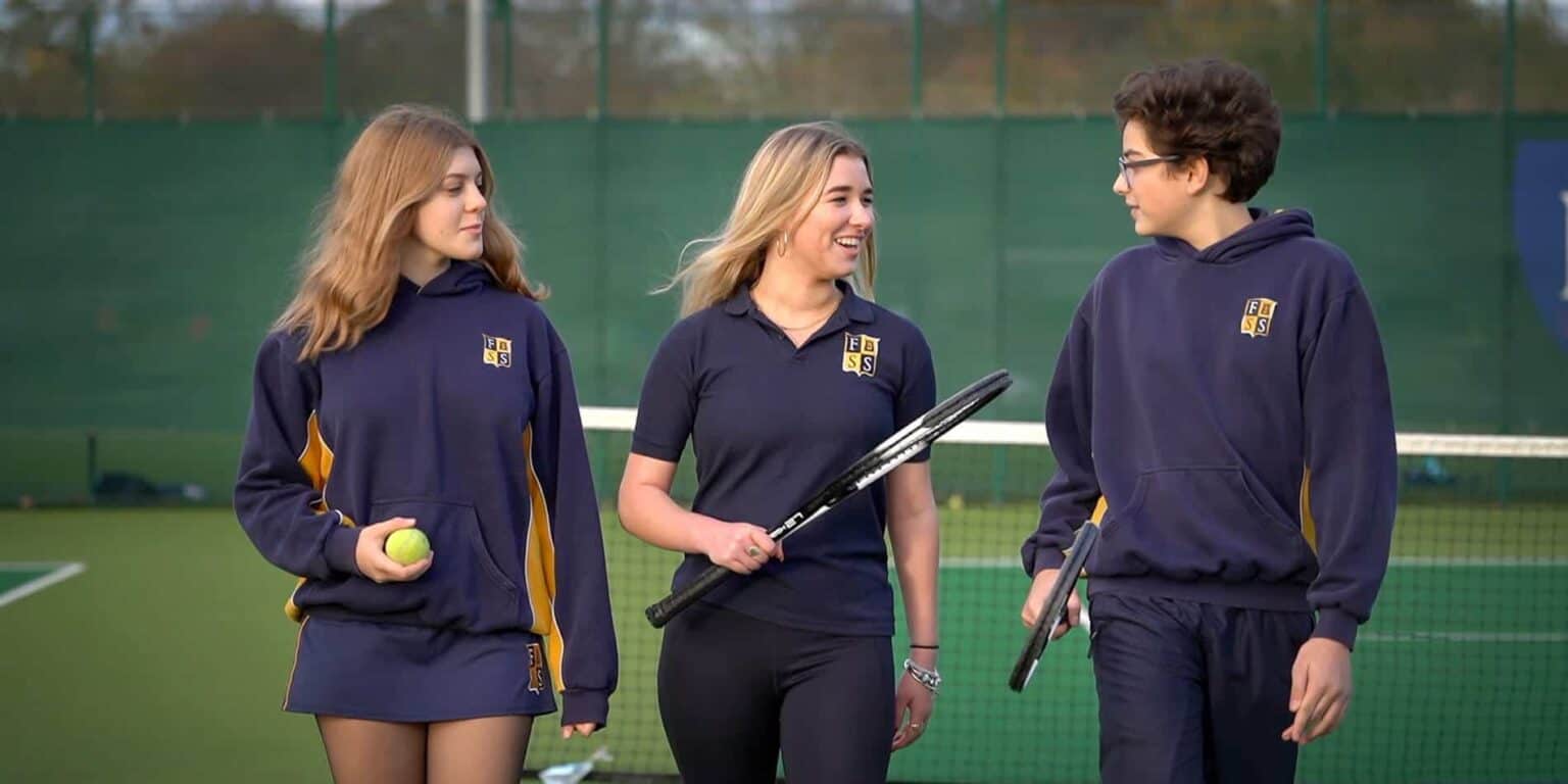 Bright students enjoying tennis practice at World Schools sports facility for a holistic education experience.