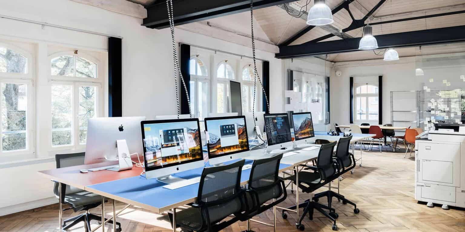 Modern computer lab with Apple iMacs and natural lighting for innovative student learning.