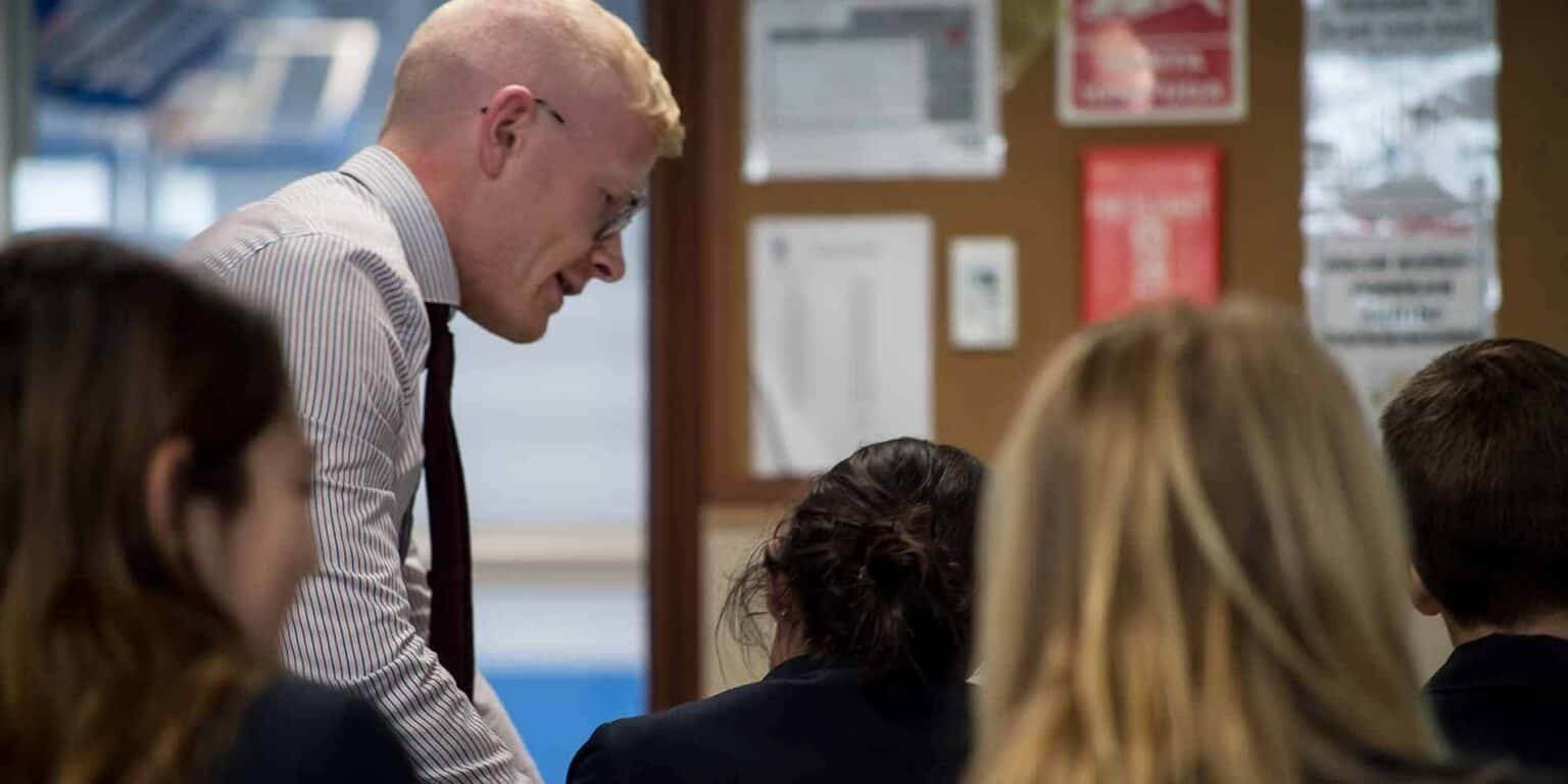 Focused teacher assisting students in classroom at World Schools.