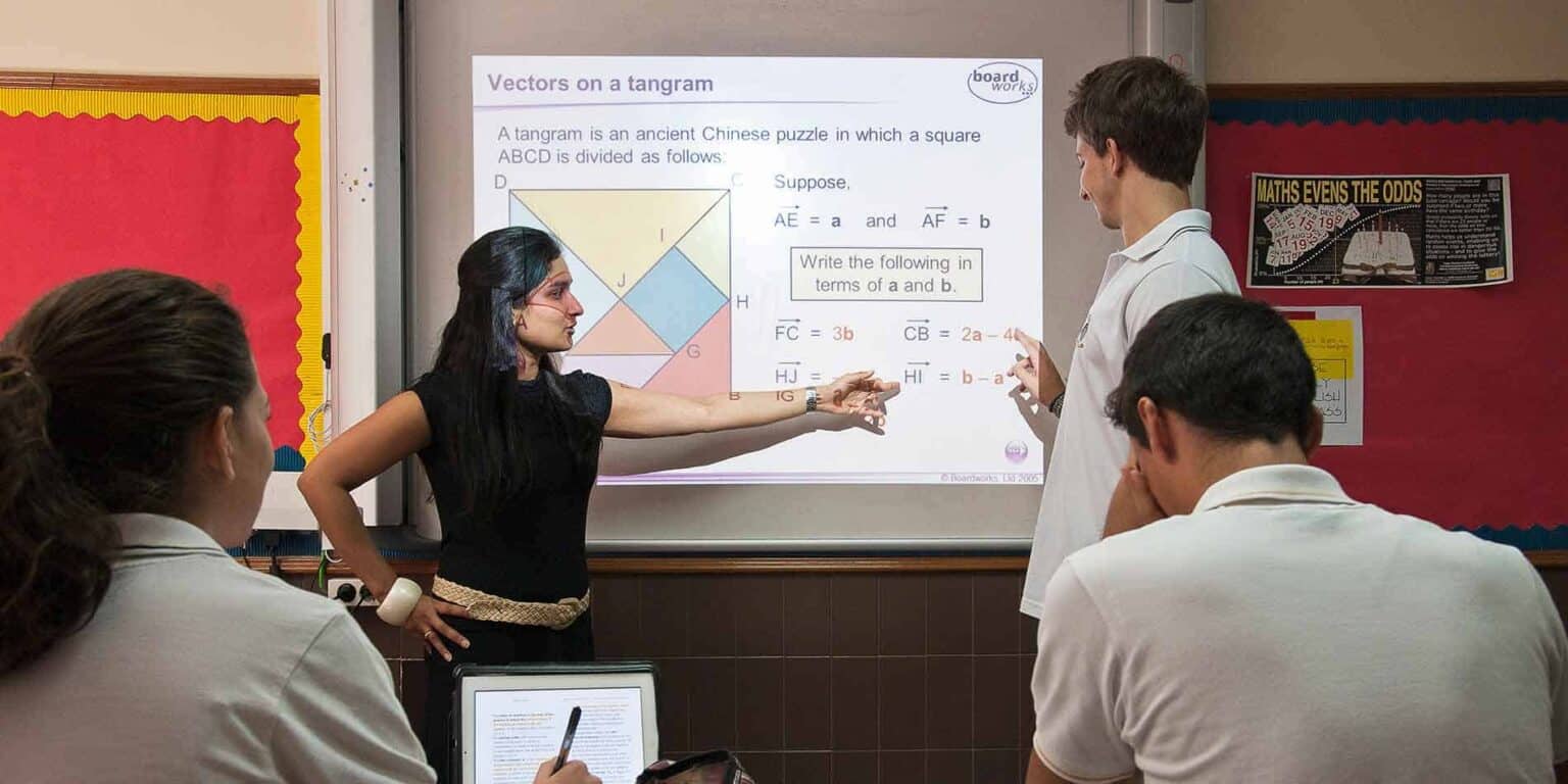 Advanced classroom scene with teachers teaching math on interactive whiteboard at a World Schools.