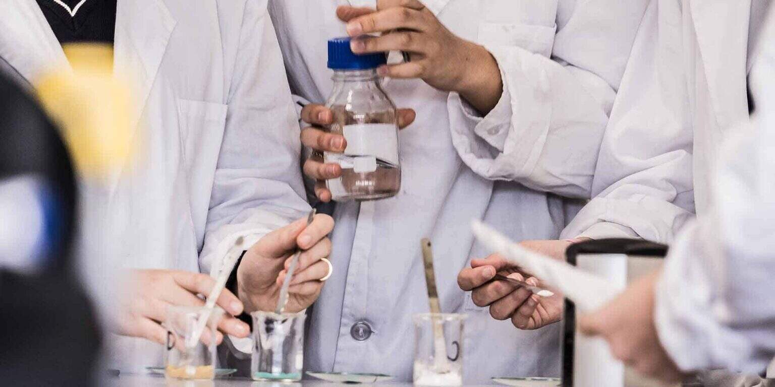 Students conducting scientific experiments in a laboratory for international education and science excellence.