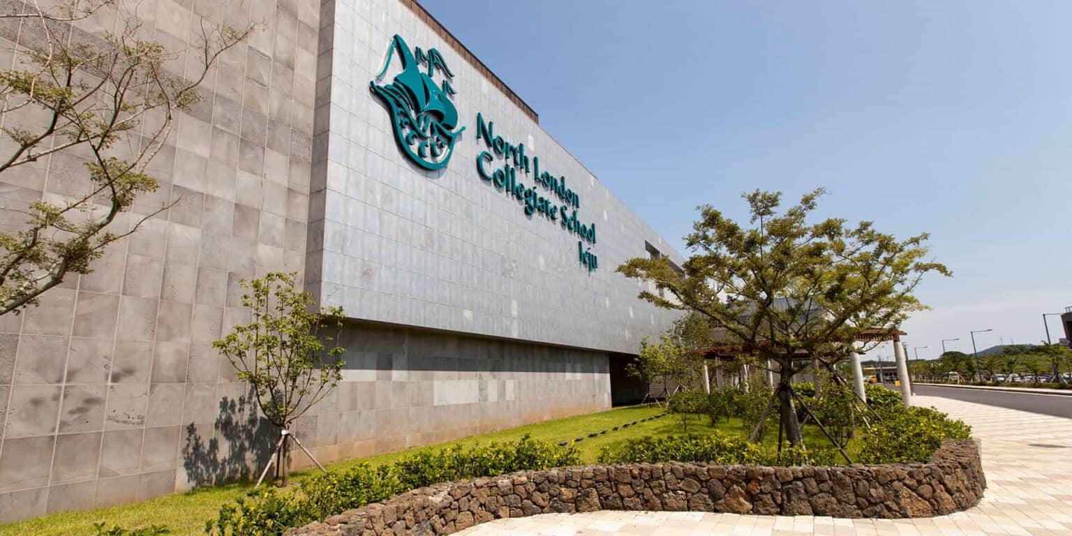 Modern North London Collegiate School logo on contemporary school building exterior.