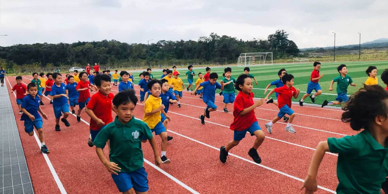 Children participating in outdoor sports at a school track and field event.