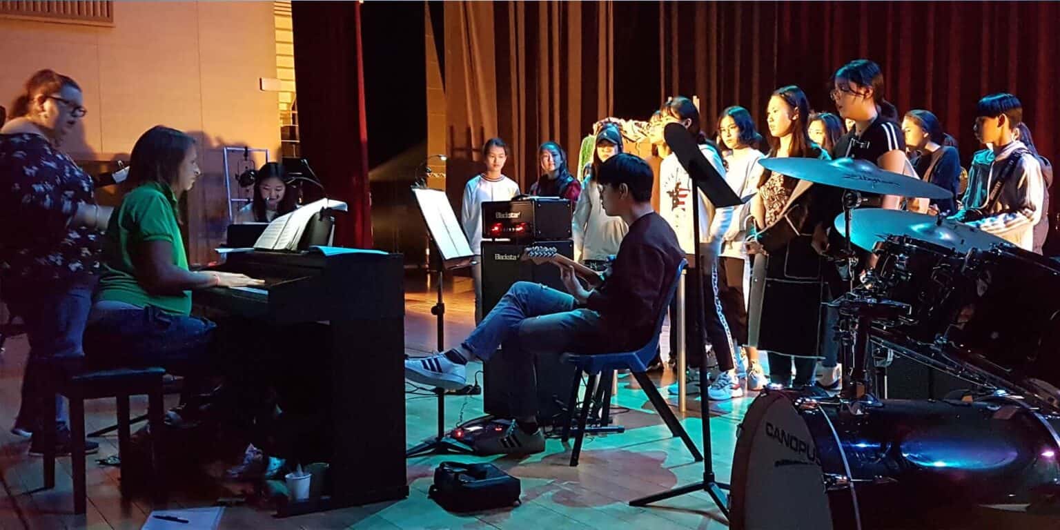 Piano students and choir perform during a music rehearsal at a World Schools event.