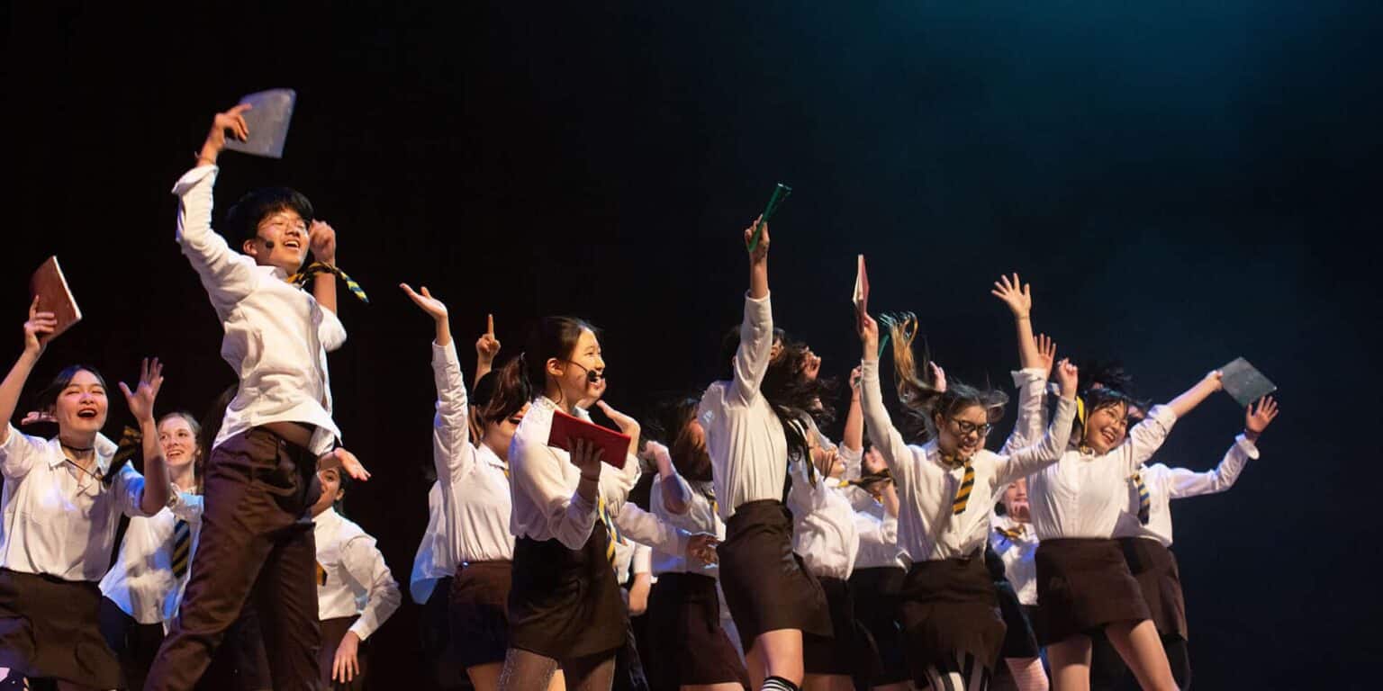 Bright students celebrating success at World Schools private education event.