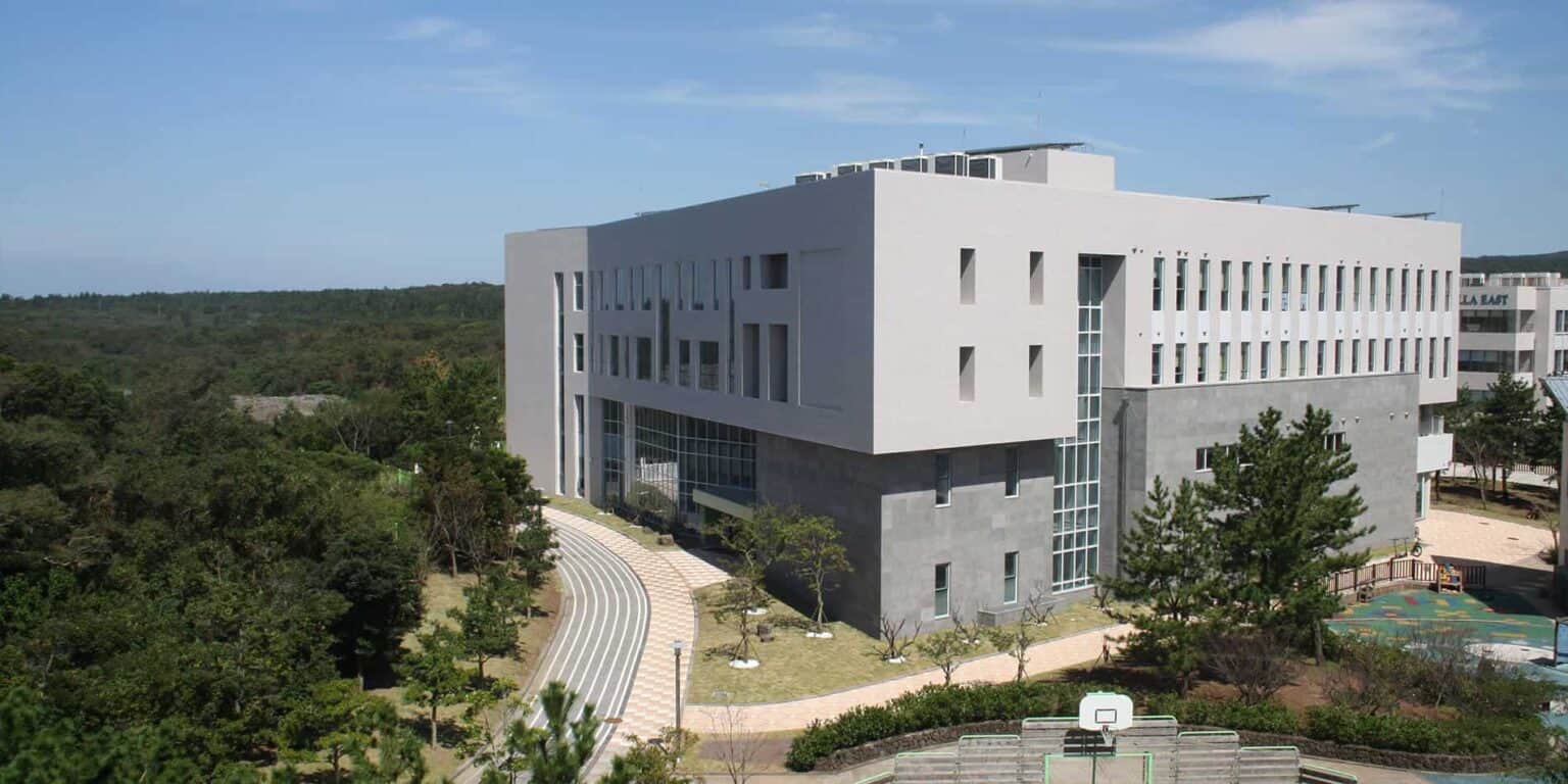 Modern educational campus building with spacious outdoor areas and lush greenery, ideal for innovative learning environments.