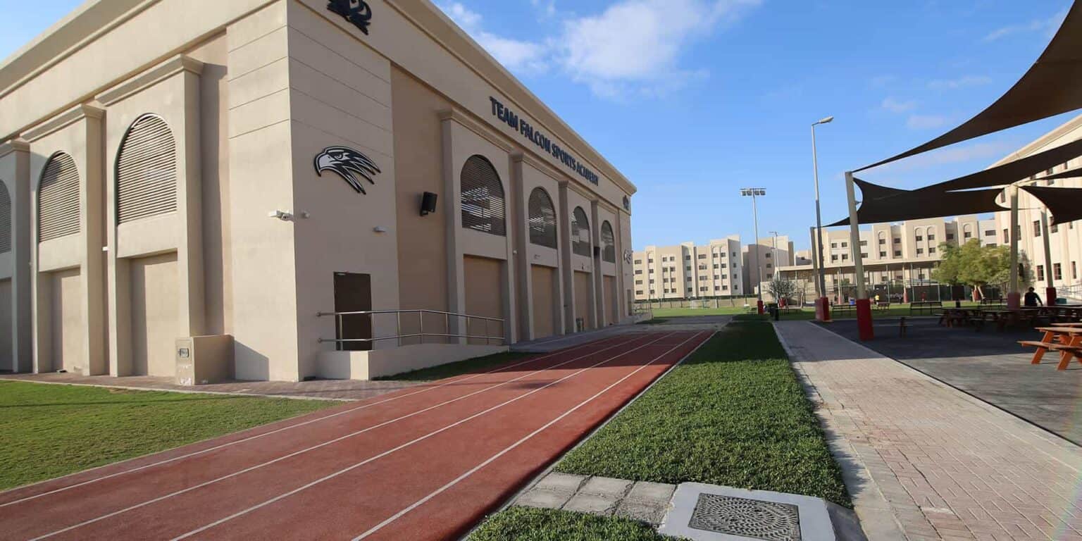 Moderno edificio escolar con instalaciones deportivas y zona de deportes al aire libre para los alumnos.