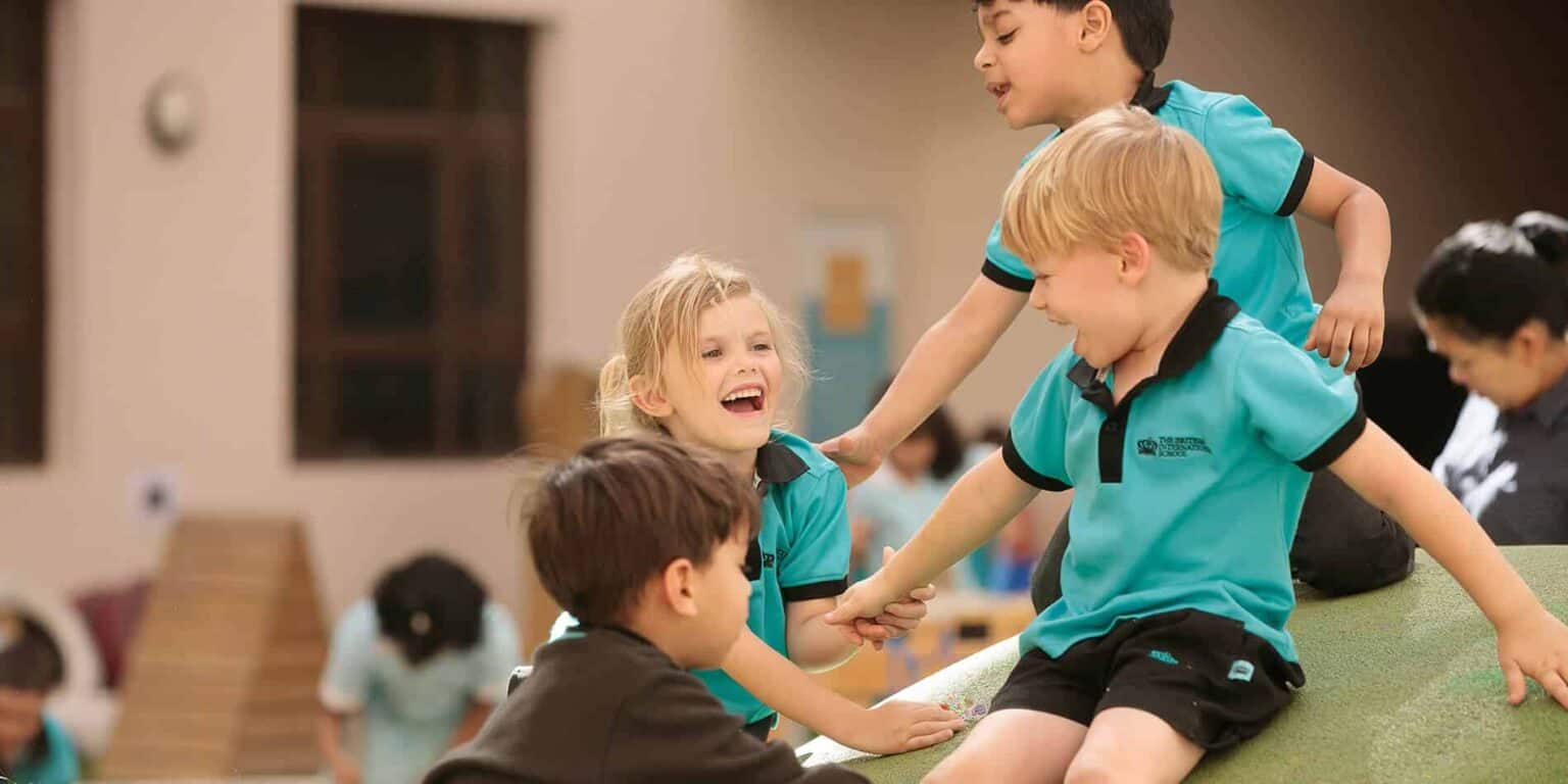 Diversos niños felices jugando y riendo en la escuela.