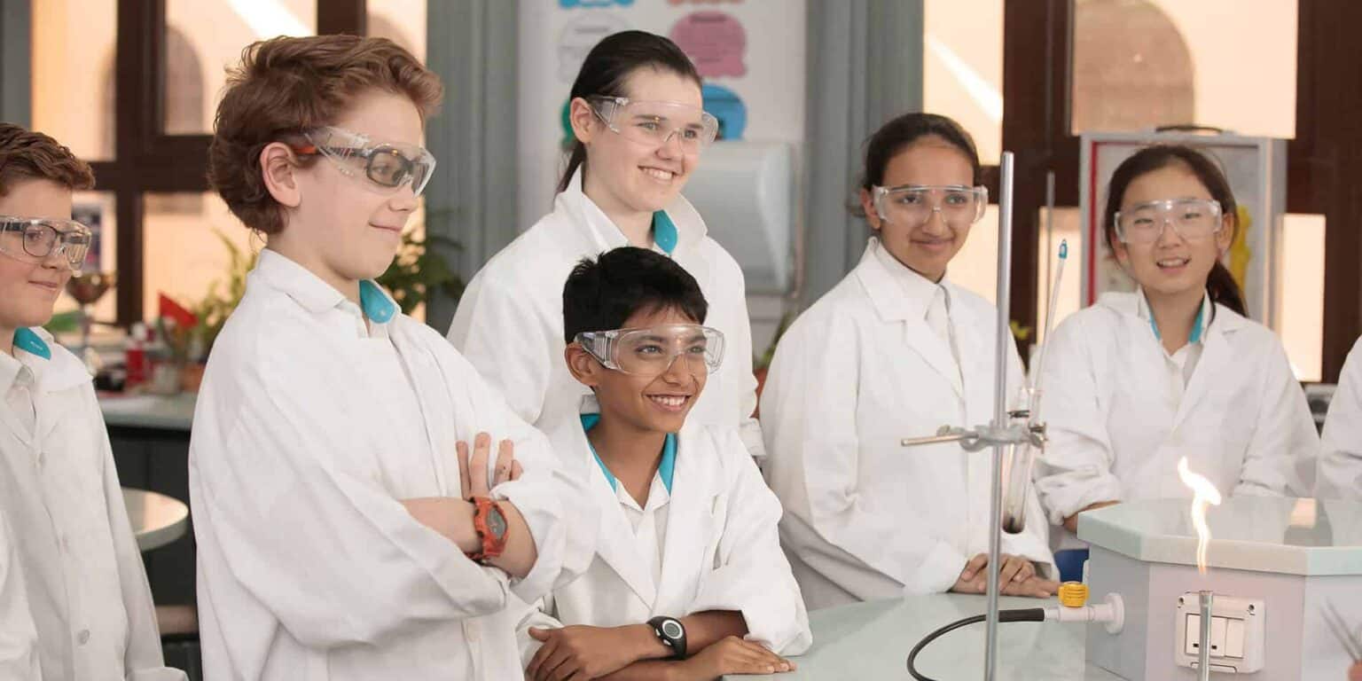 Alumnos realizando experimentos científicos en un aula de un programa de los Colegios del Mundo.
