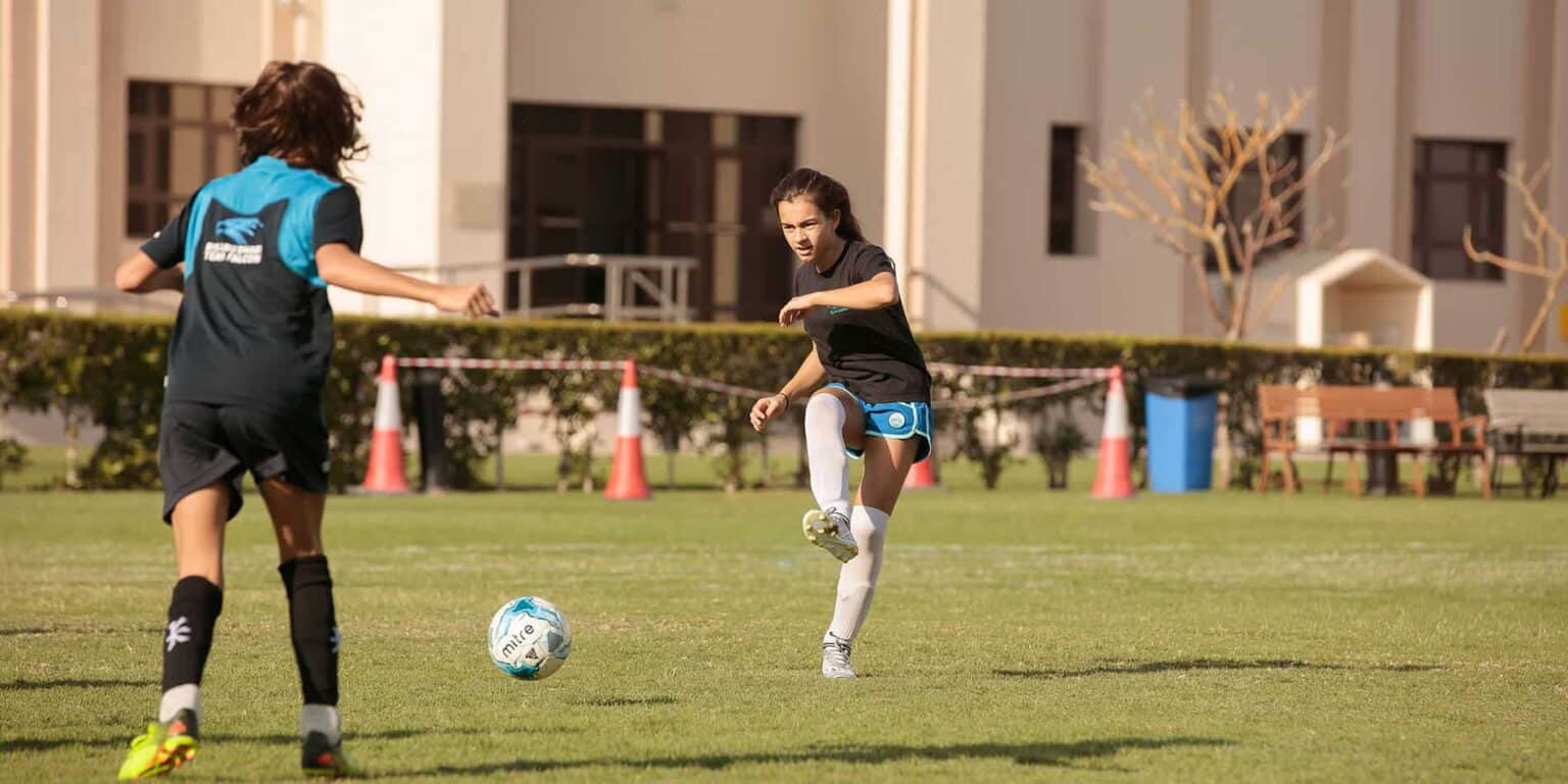 Niños activos jugando al fútbol en los Colegios del Mundo, fomentando el deporte y el desarrollo saludable.