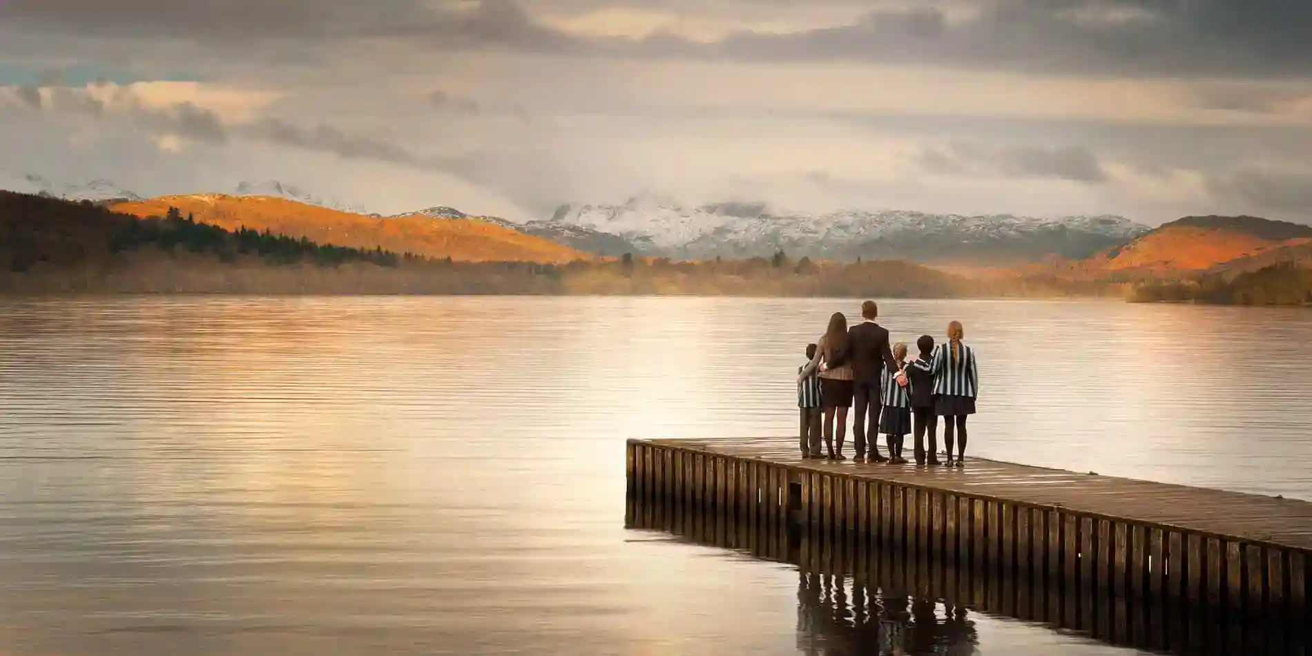Szkoły 3 Serene lake scene with students and teacher on dock, emphasizing global education and school community.