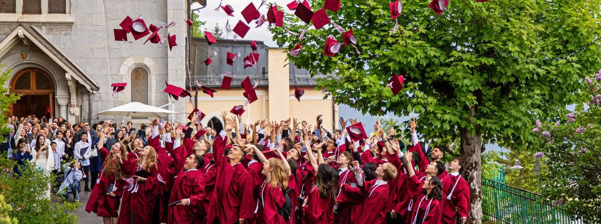 Graduates throwing caps in outdoor school graduation celebration.