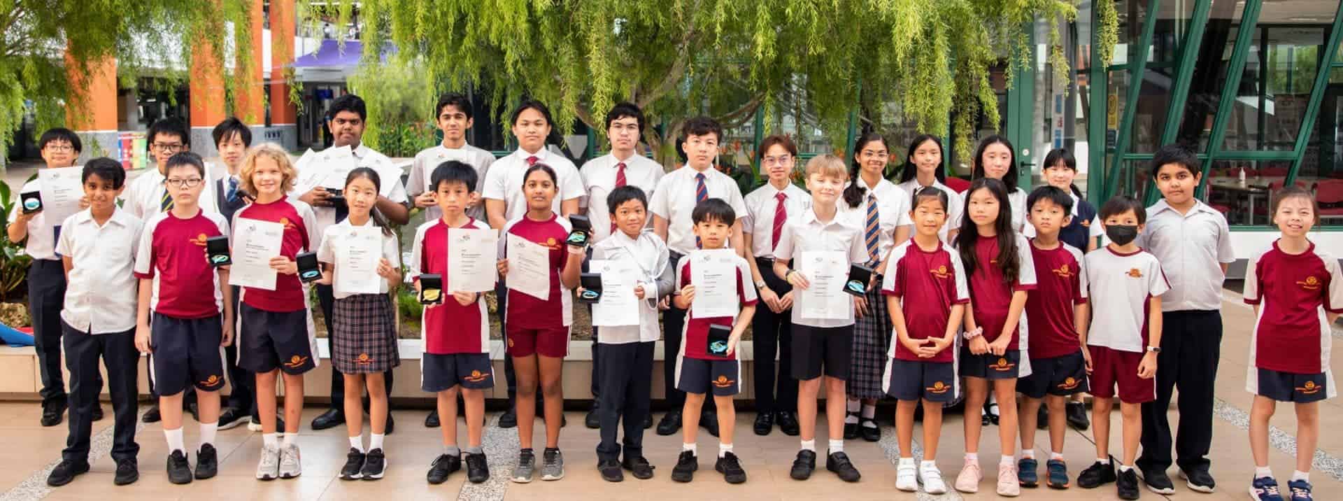 Bright diverse students holding certificates at an international school event.