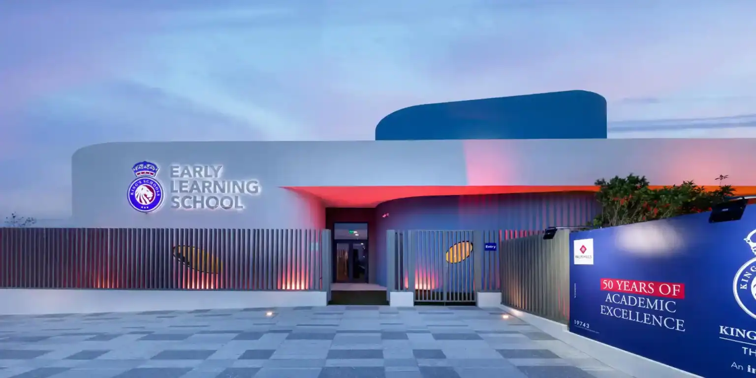 Bright modern early learning school building with vibrant lighting and signage, promoting academic excellence and international education.