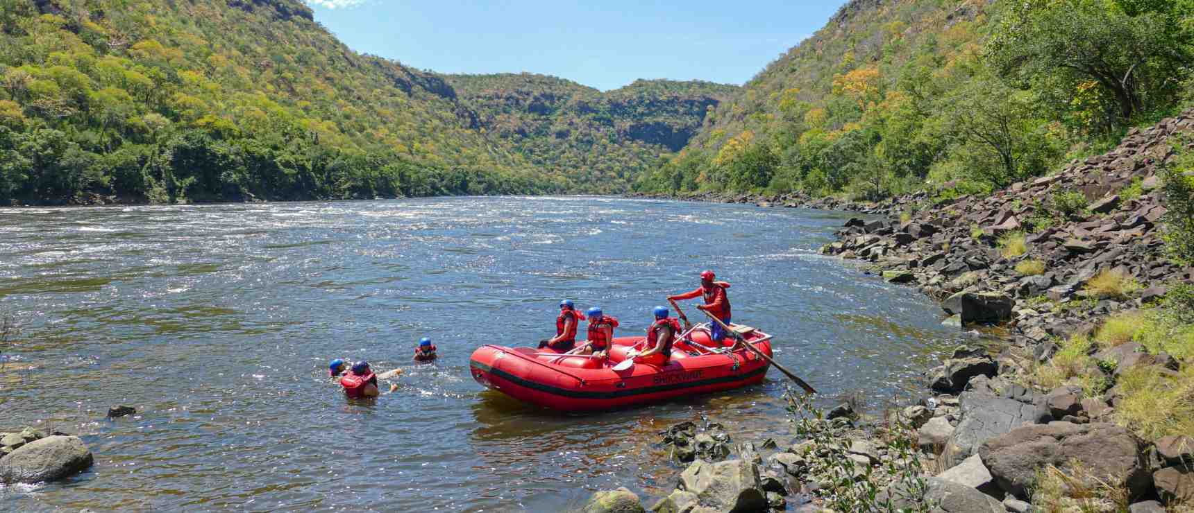 Rafting adventure on a river surrounded by lush green mountains, perfect for outdoor activities and nature exploration.
