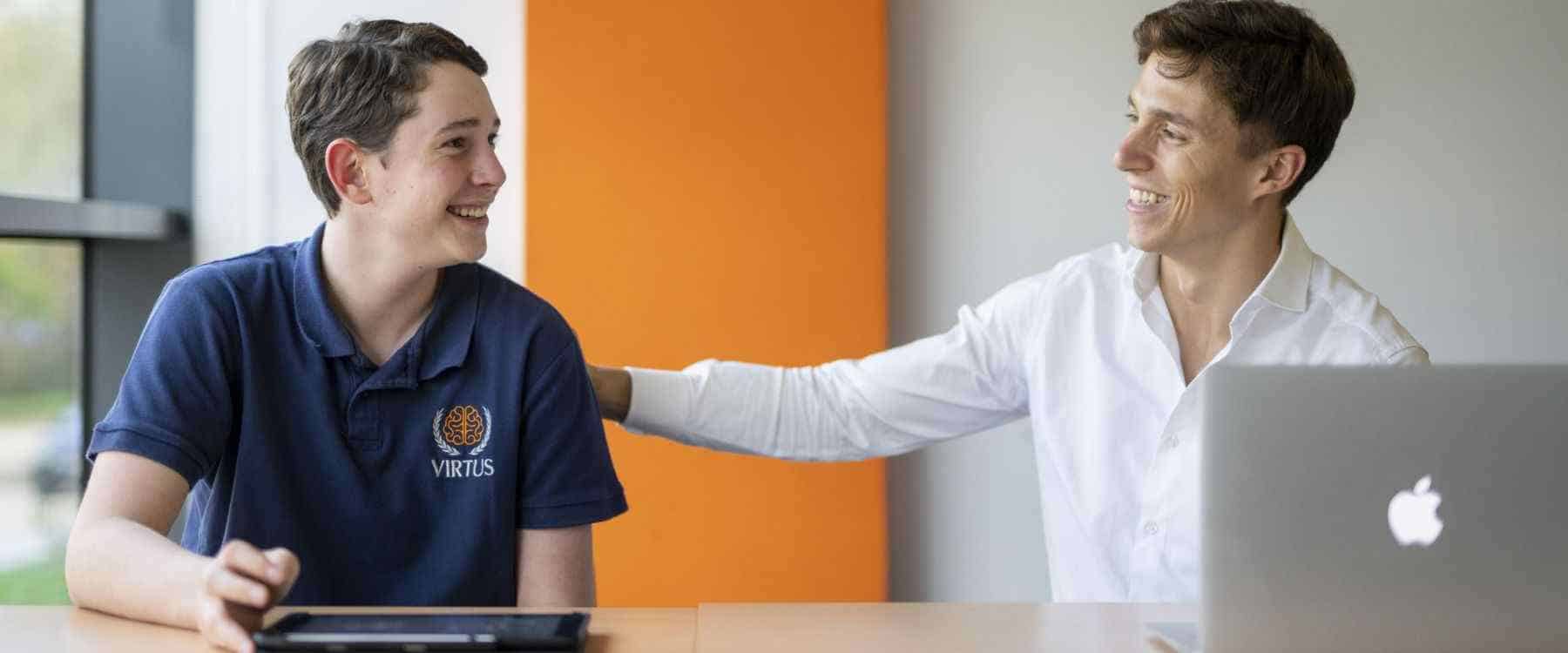 Committed high school student receiving guidance from a caring teacher in a modern classroom.