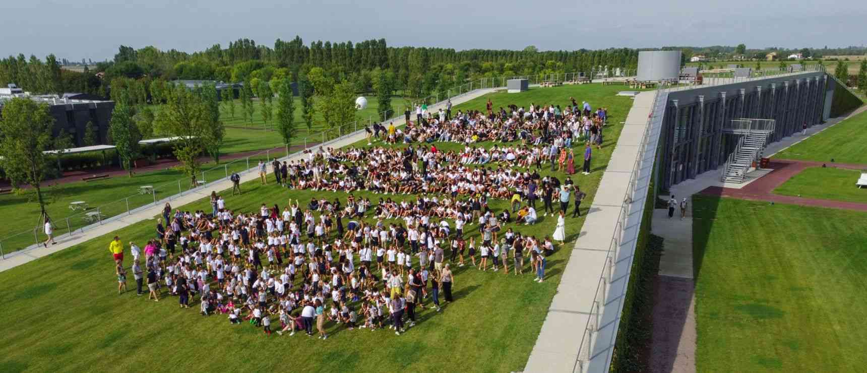 Students gathering outdoors at a modern international school campus for educational activities and events.