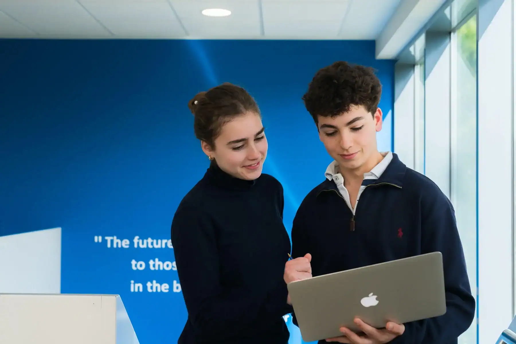 Students collaborating with a laptop at Liceo Europeo.